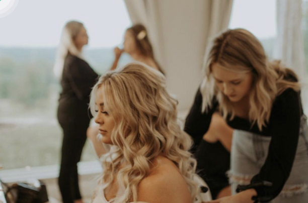 Erika Taft Bridal hair artist meticulously styling the bride's hair during the getting ready process, ensuring perfection for her special day.